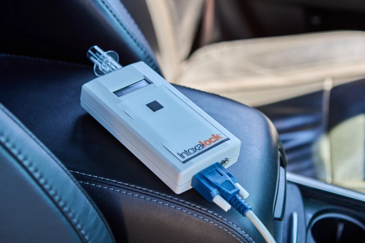 Close-up of an Intoxalock ignition interlock device resting on the center console of a car.