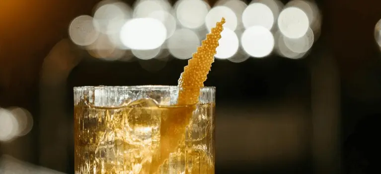 Amber cocktail with ice and a twist