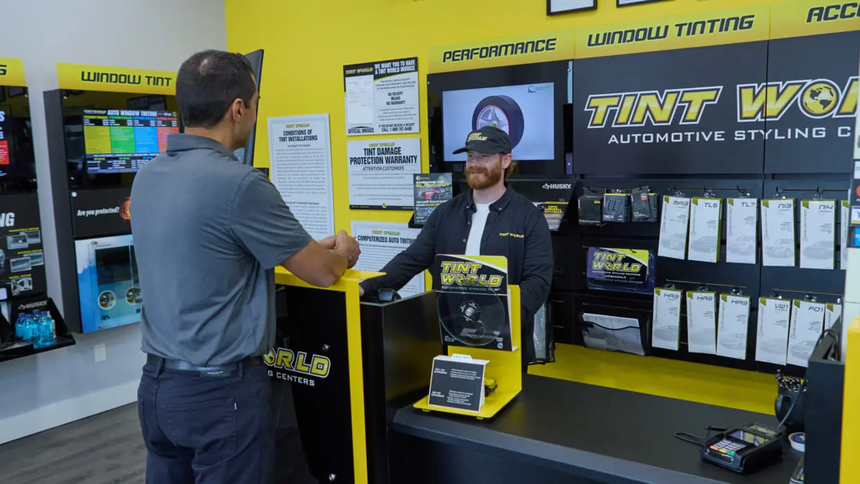 Customer visiting a service center counter for ignition interlock device removal, interacting with a service technician